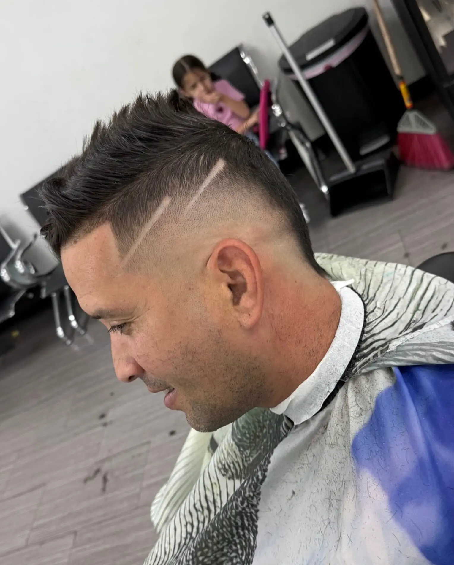 Textured crop with a sharp fade and parallel razor lines near the ear